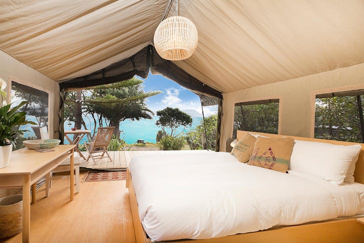 Glamping tent at slipper island looks out over impossibly blue sea.