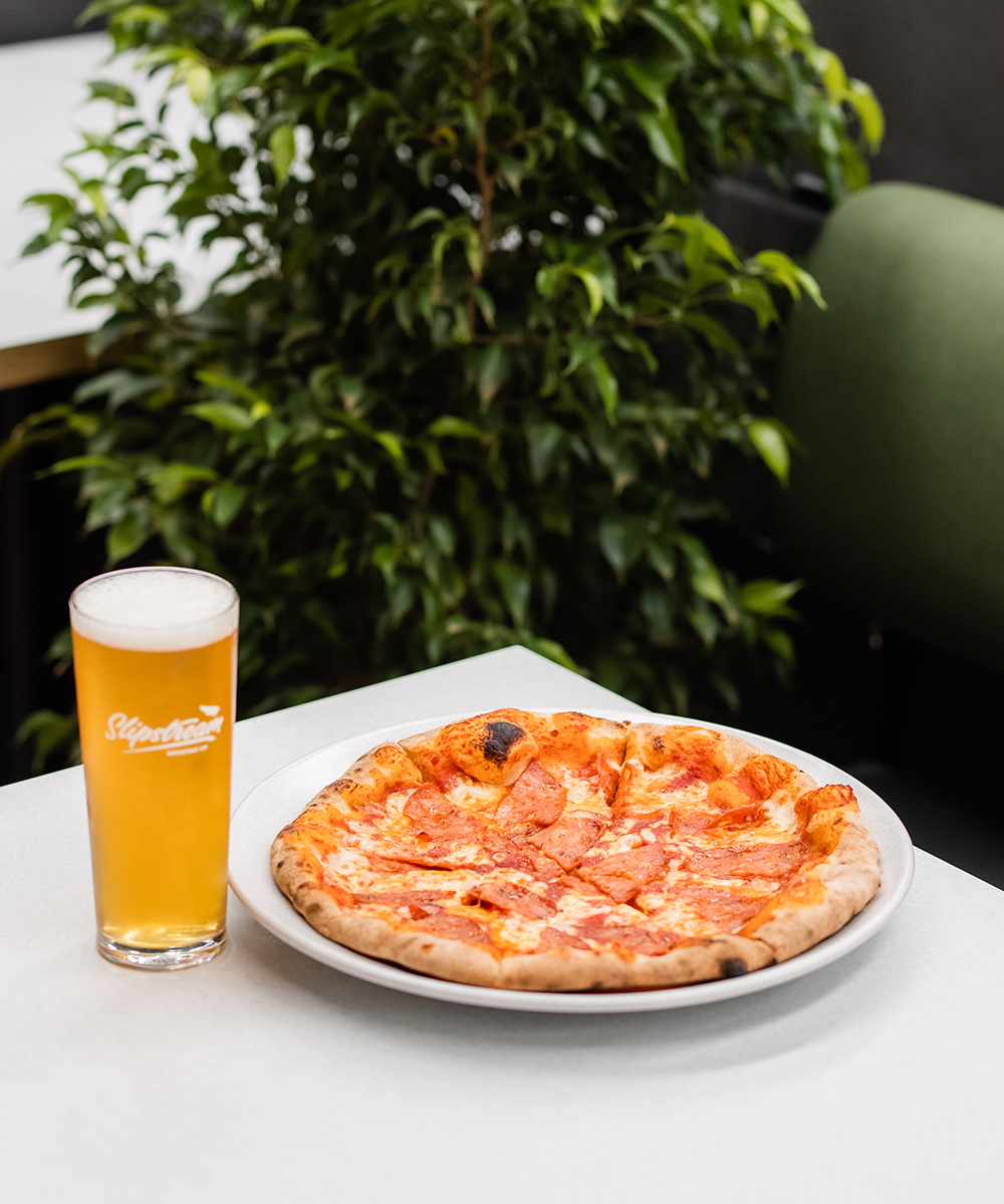 a pizza and a beer on a table