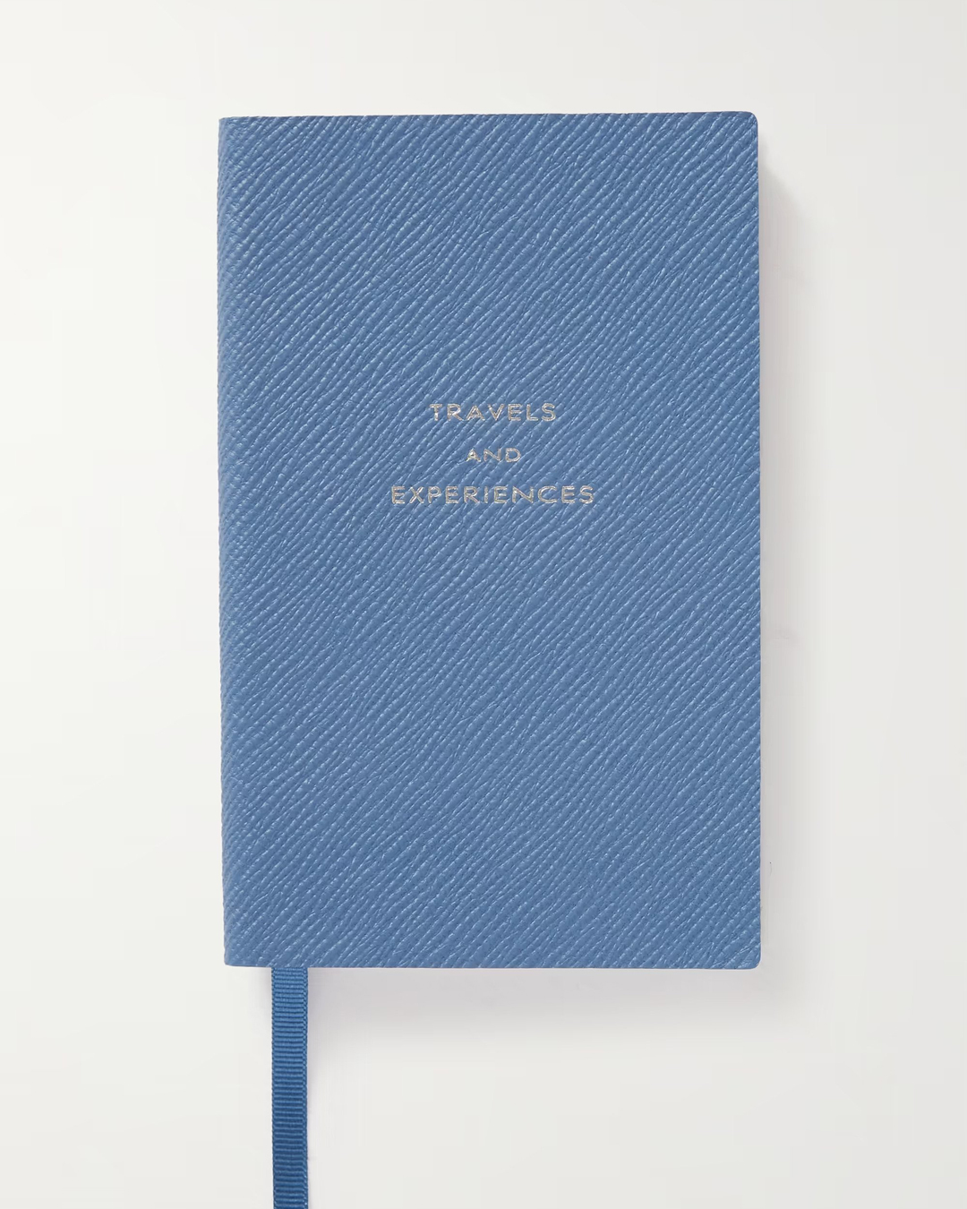 A blue textured notebook with 'travels and experiences' embossed in silver.