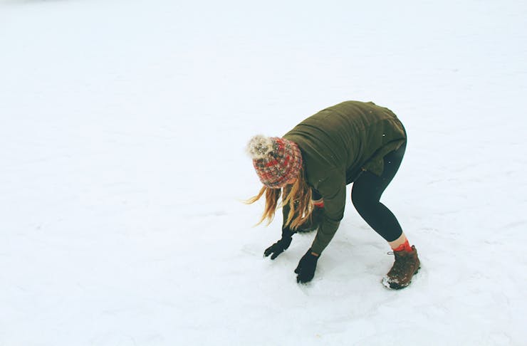 a woman picking up snow 