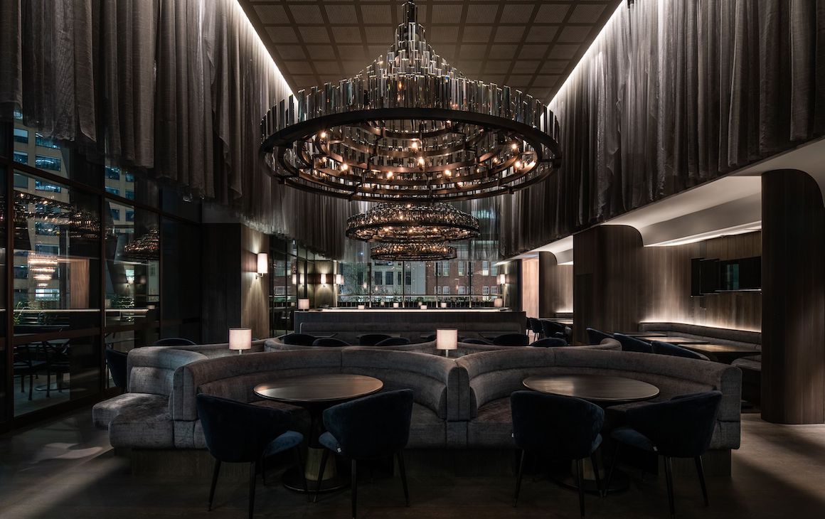 a dark and moody restaurant with a large chandelier