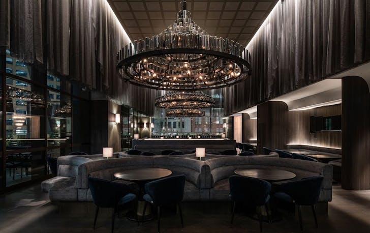 a dark and moody restaurant with a large chandelier
