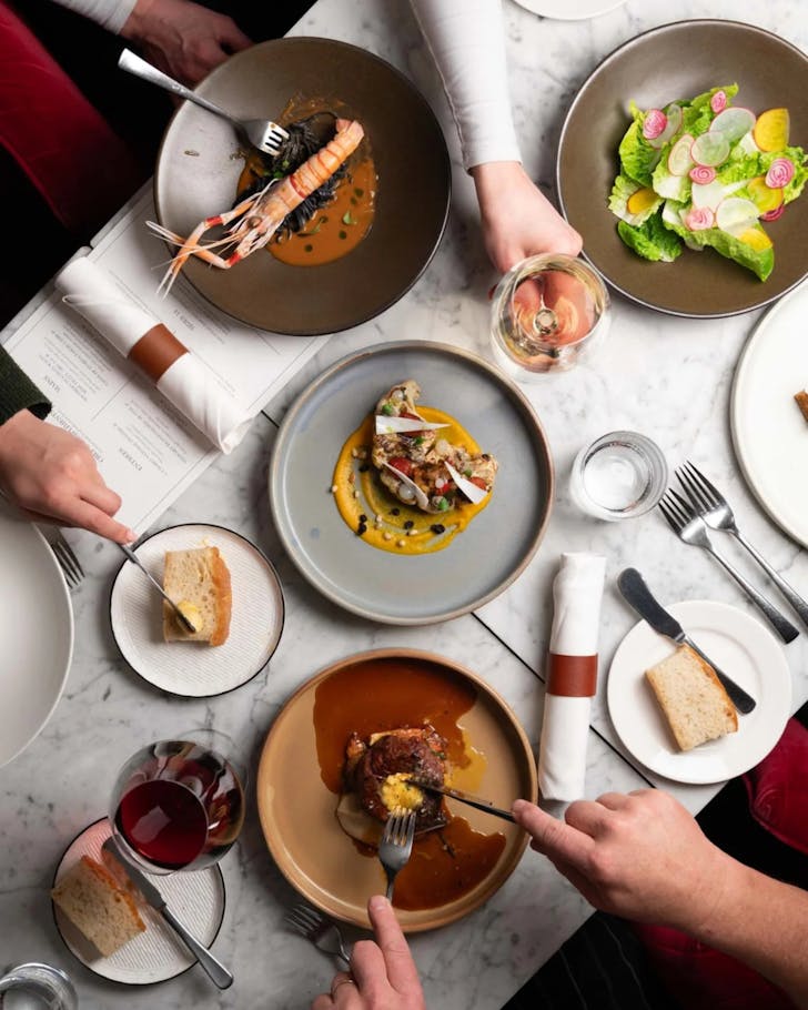 Dishes and glasses of wine at Le Salon Rouge in Queenstown