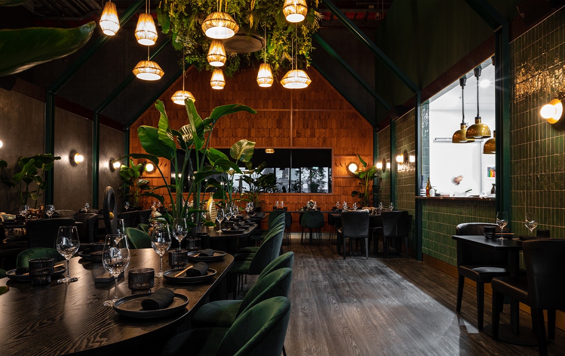 a moody dining area with lots of greenery