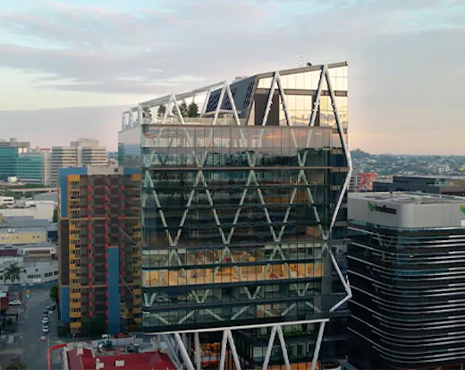 a glass building with a rooftop bar on top