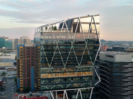 a glass building with a rooftop bar on top