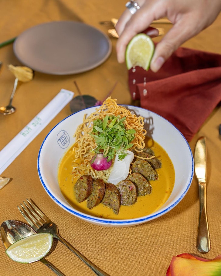 plate of food with hand squeezing lime
