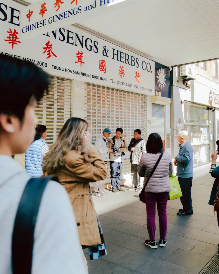A group pauses outside a long-running Chinese herbal medicine store in Sydney's Chinatown