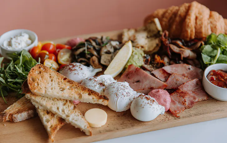 a board piled with breakfast food