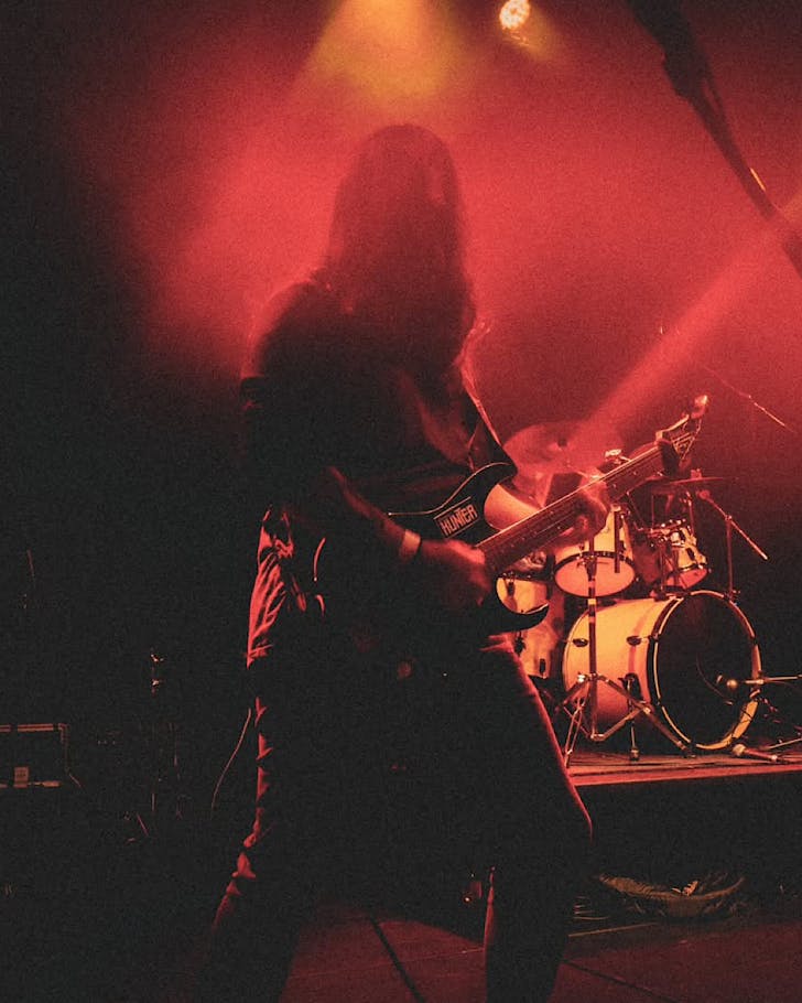 Soul Stroke rock out on a dark, orange & red-lighted stage.