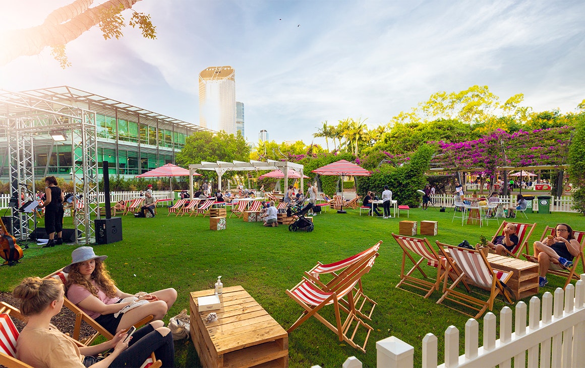 people sitting on lawn chairs in a grassy area
