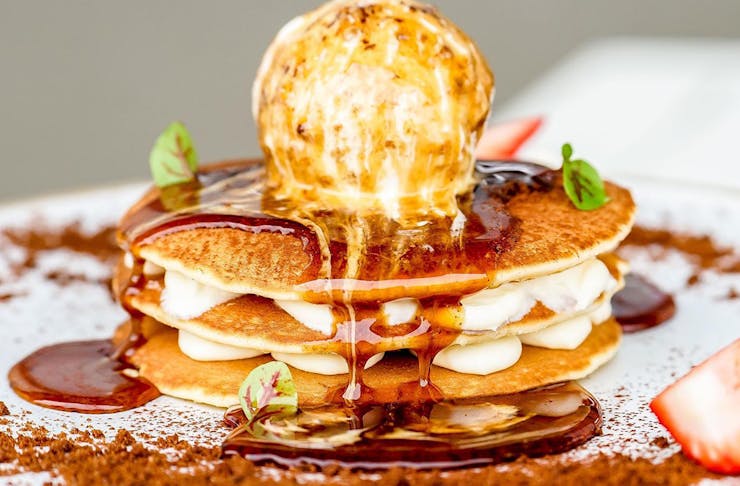 a stack of pancakes dripping in syrup