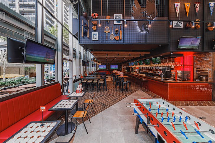 inside of winghaus with screens and a foosball table