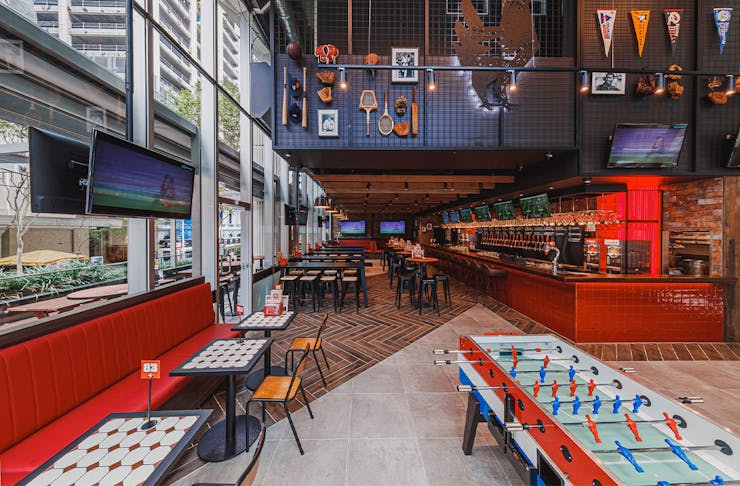 inside of winghaus with screens and a foosball table