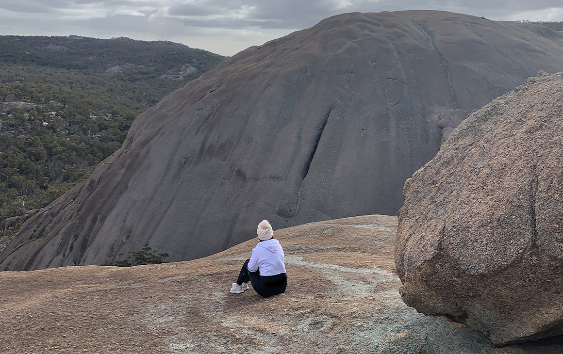 a person sitting on a granite mountain