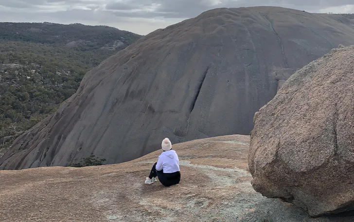 a person sitting on a granite mountain