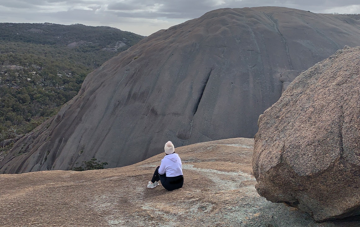 a person sitting on a granite mountain