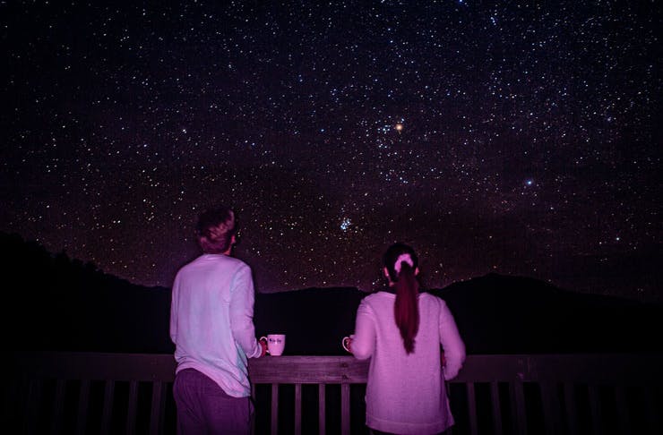 Two people stargazing with a view of the Southern night sky. 