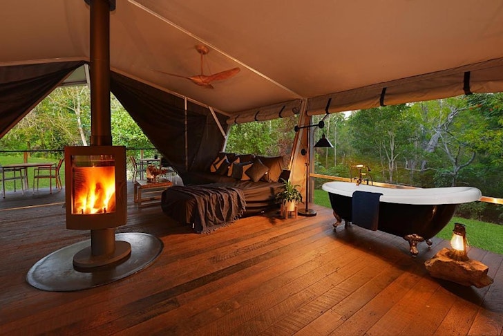 A tent with a wood burner in it at Starry Nights Luxury Camping one of the best glamping spots in Queensland.