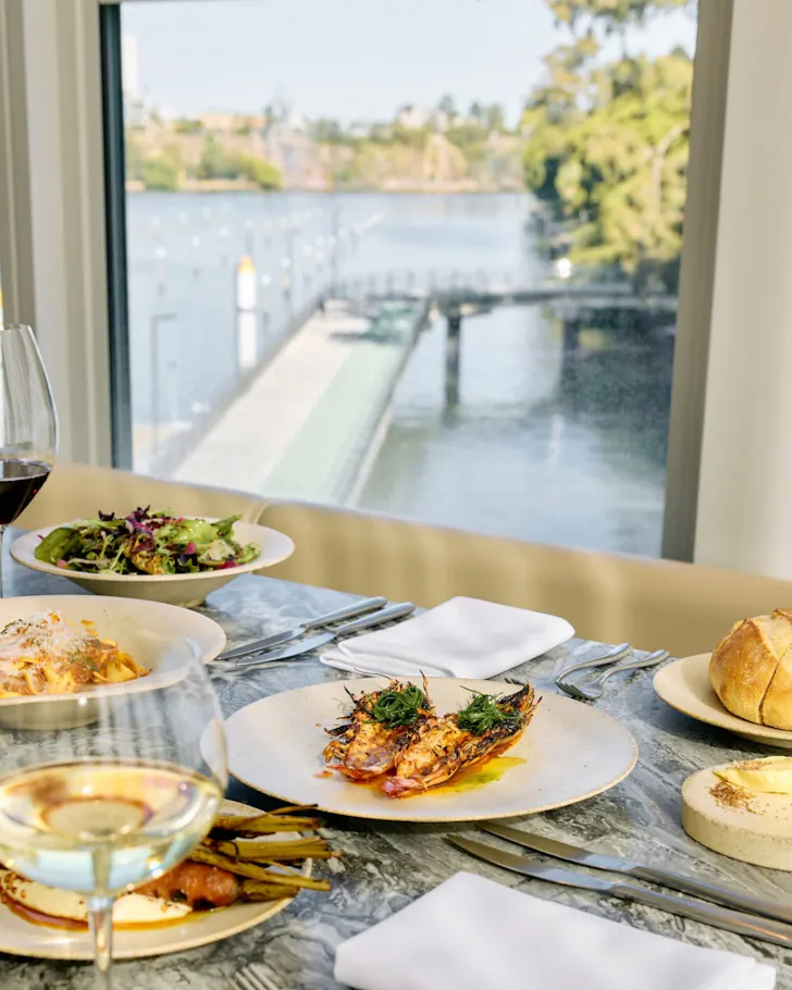 A spread of seafood-forward dishes at a table overlooking the Brisbane River at Stilts.