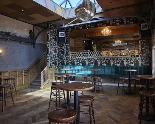 The interior of a moody cocktail bar above a brewery.