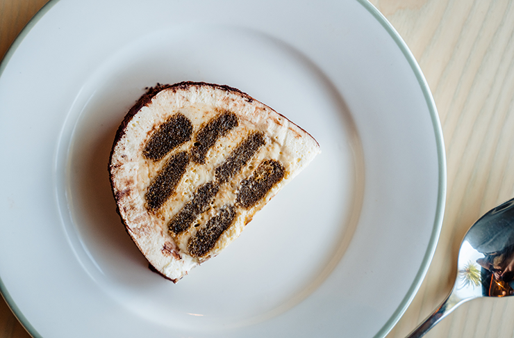 A slice of a melbourne tiramisu on a white plate. 