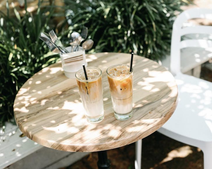 An outdoor table with two iced coffees on it at a dog friendly cafe in Perth