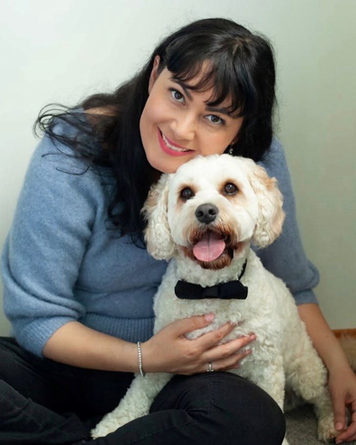 Author Hydie Hande-Balle holds her little white dog Archer.