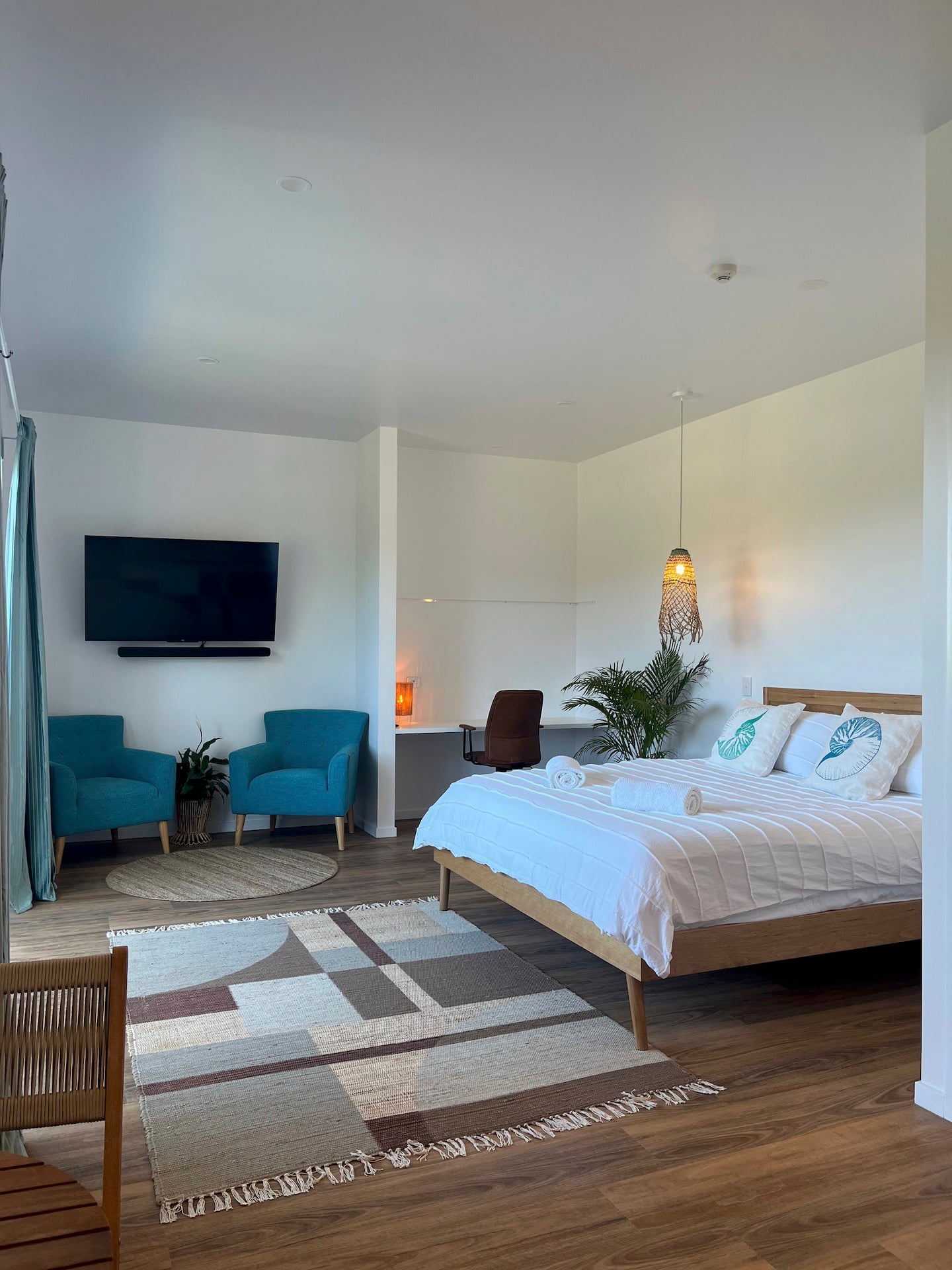 a stradbroke island accomodation with a bed and lounges in a hotel-style room