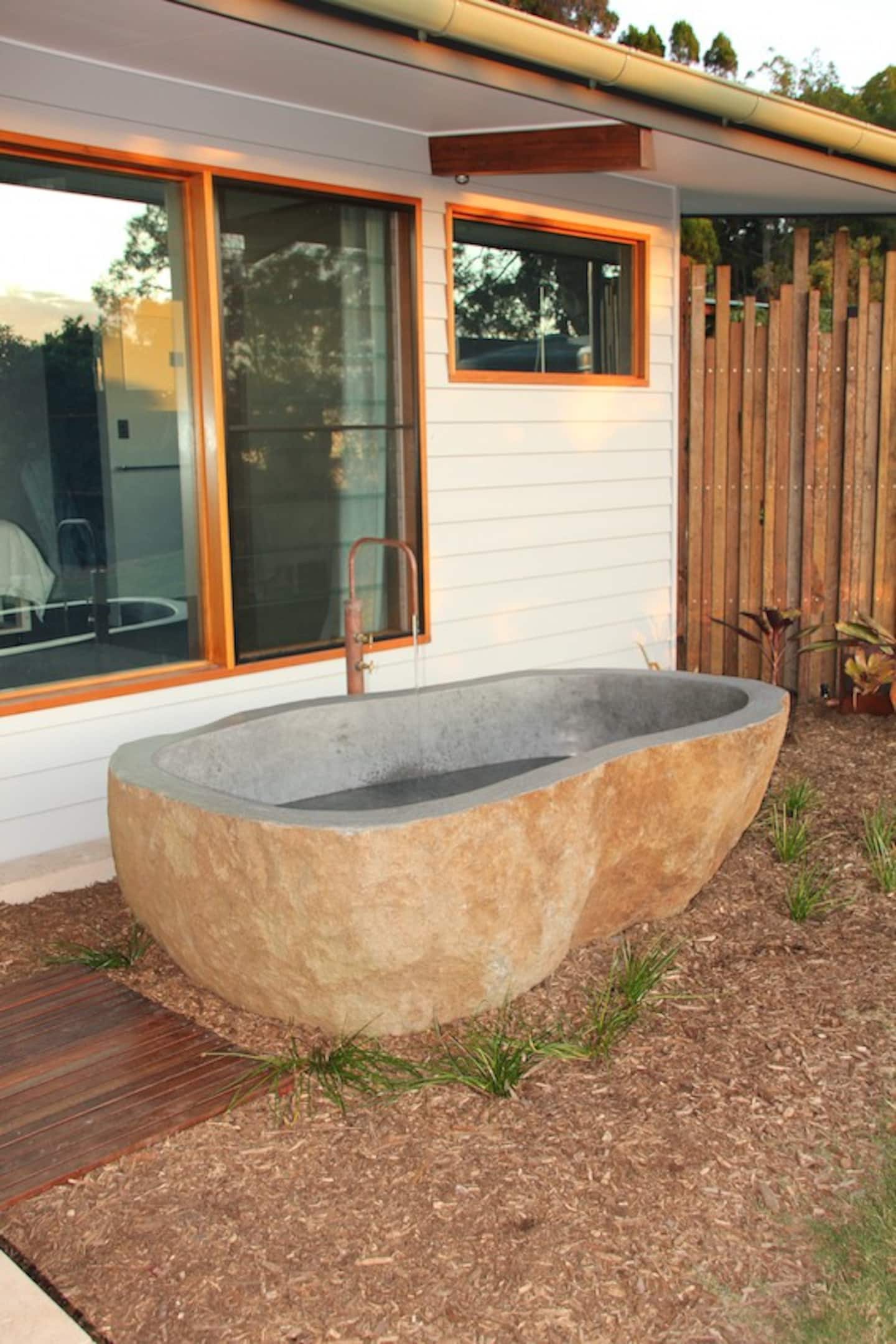 a stradbroke island accomodation with an outdoor stone bath