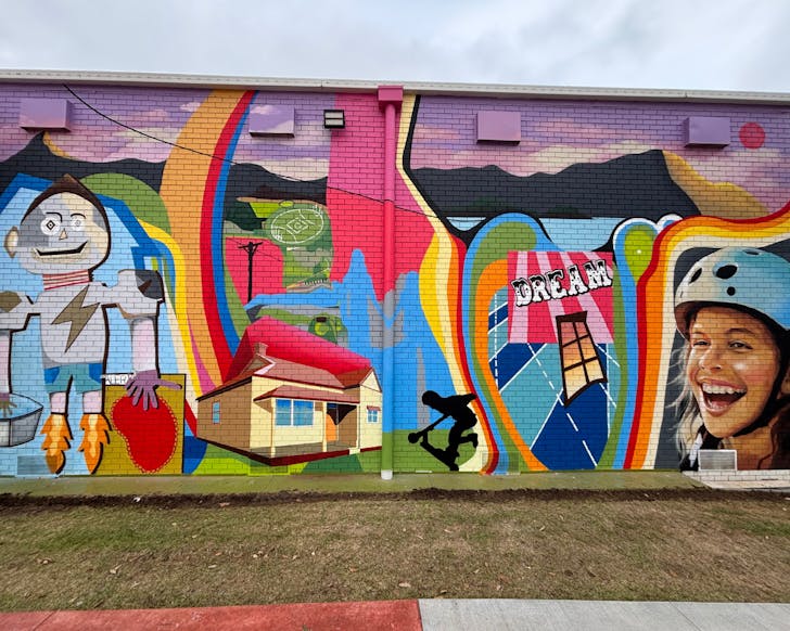 A brightly coloured street mural painted on a brick wall