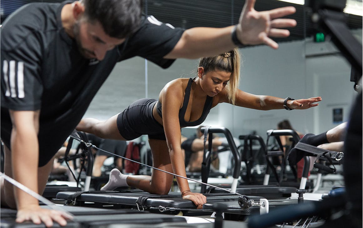 people doing exercise on a reformer bed