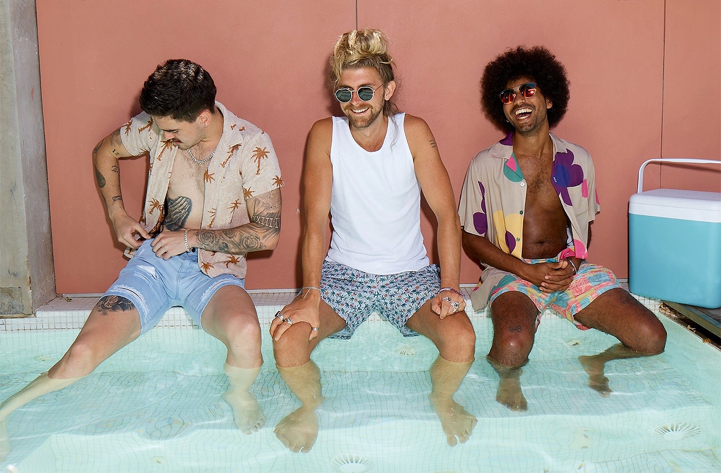 Three men in a hot tub looking happy.