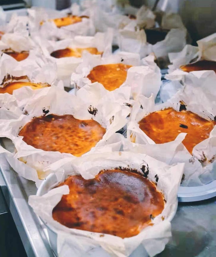 a tray of burnt cheesecakes in paper