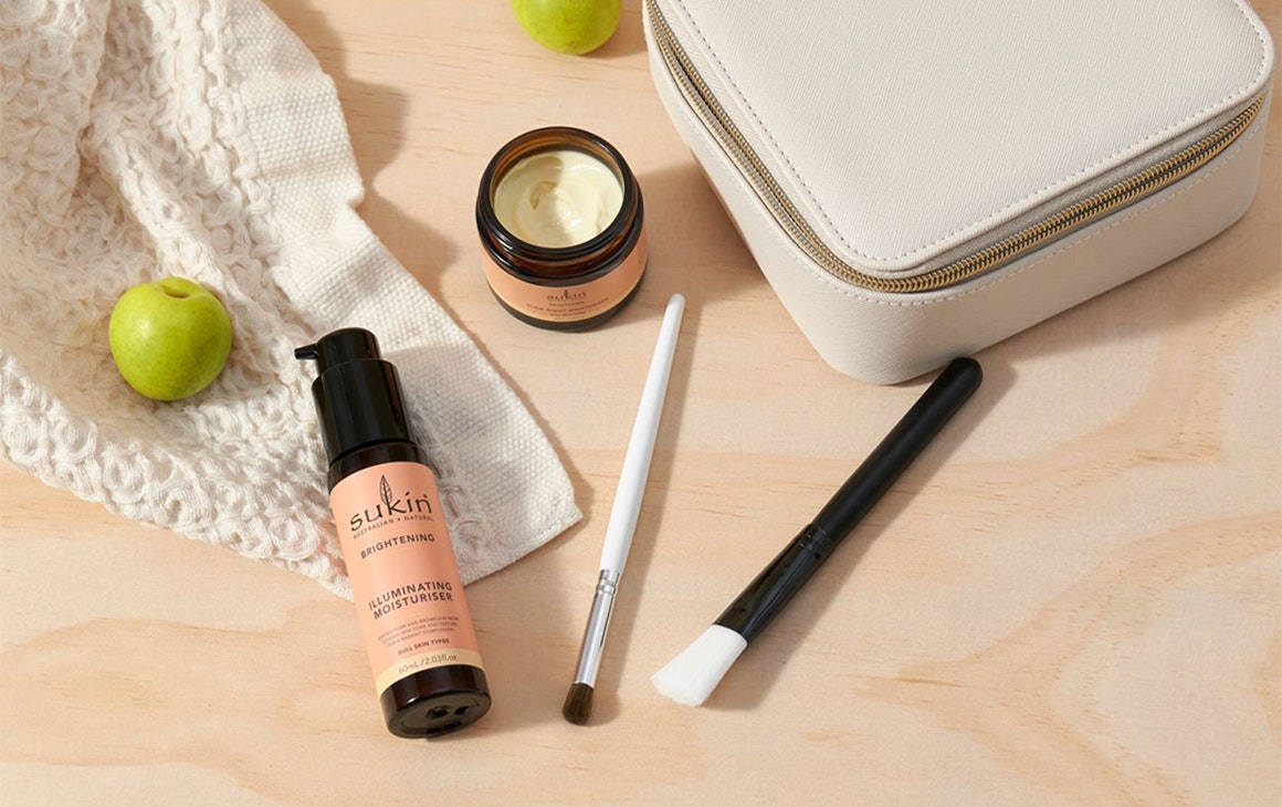 several skincare products and brushes on a bench