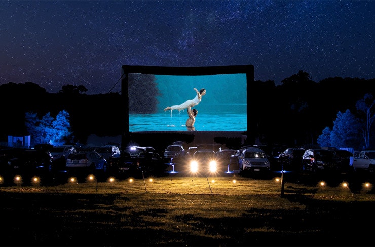 A drive in cinema at night with Dirty Dancing on the movie screen