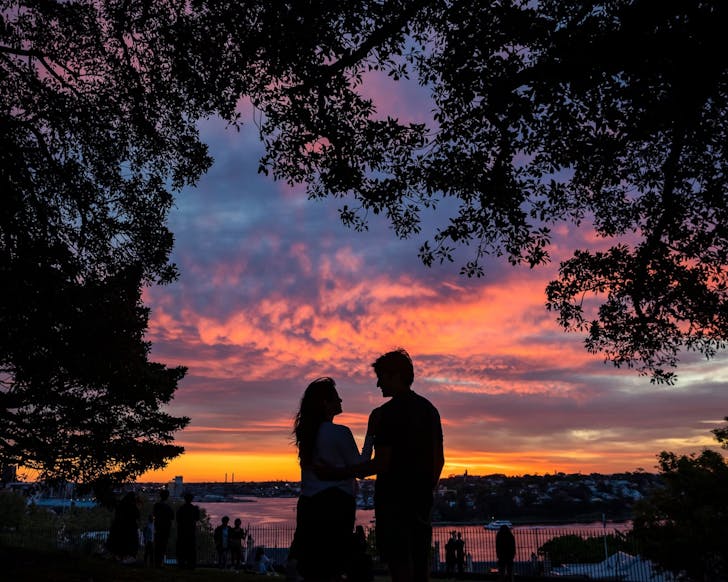 a couple watches the sunset at observatory park in sydney