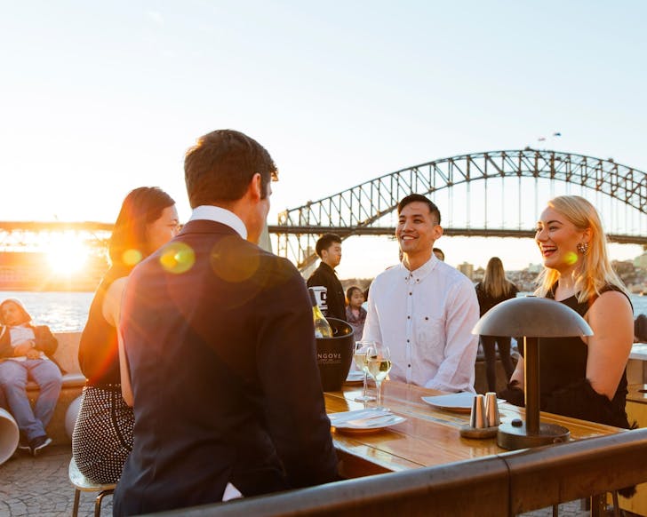 people enjoying the sunset view from opera bar on sydney harbour