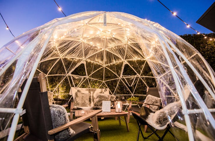 A pop-up plastic igloo with seating inside, sits at a Queensland pub. 