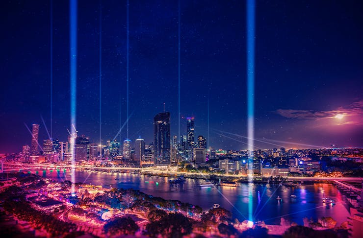 A view of the city skyline with lasers pointing to the sky