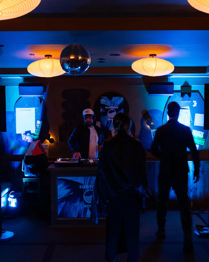 Blue lit DJ booth with disco balls at Suntory House