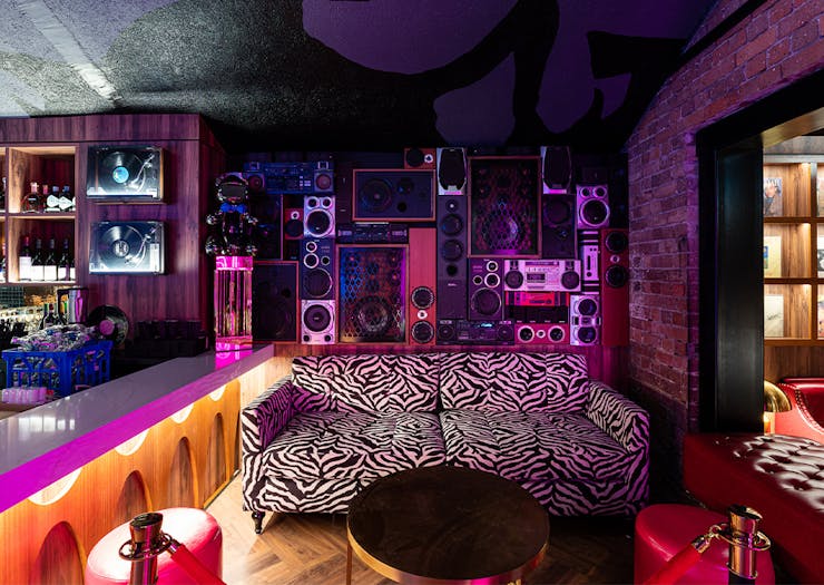 a zebra patterned couch with a wall of speakers