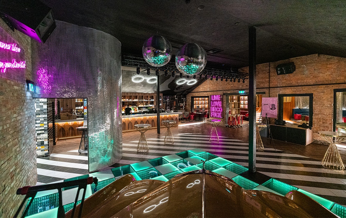 the interior of a neon lit retro bar