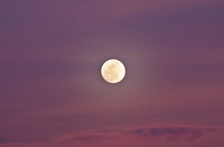 A pink moon in the night sky.