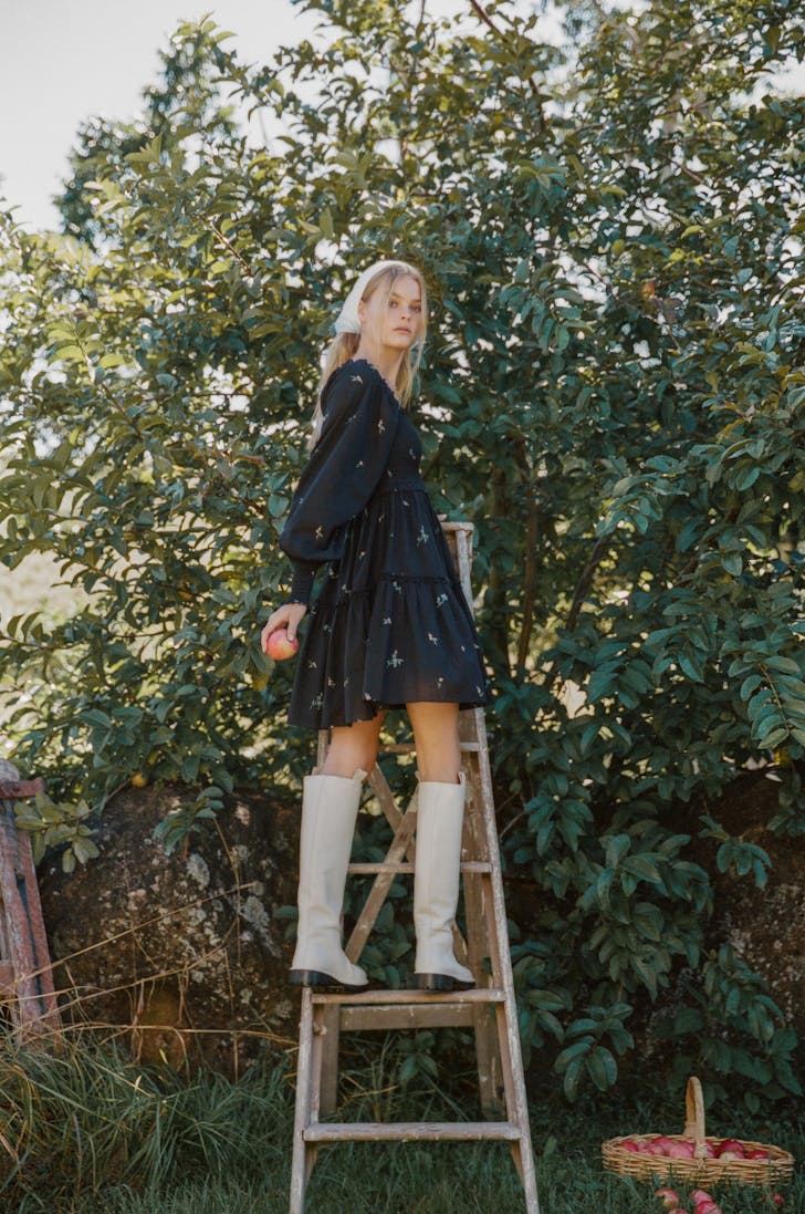 a woman in rubber boots on a ladder