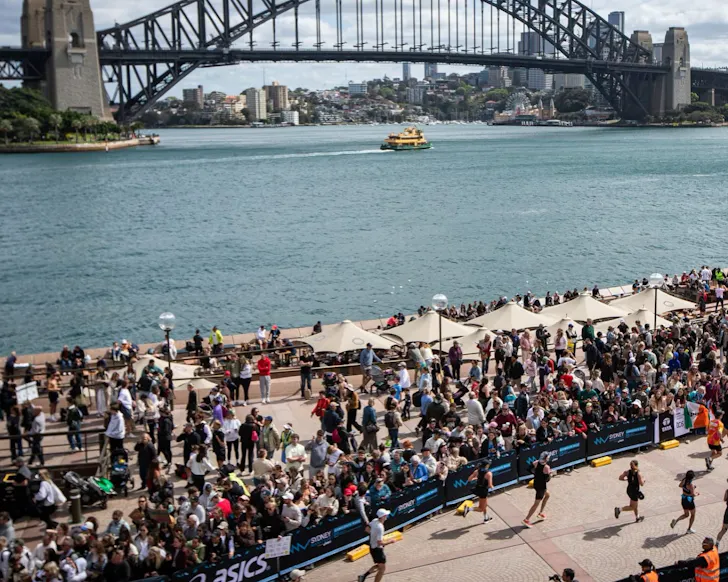 Runners file along the harbour during the Sydney Marathon