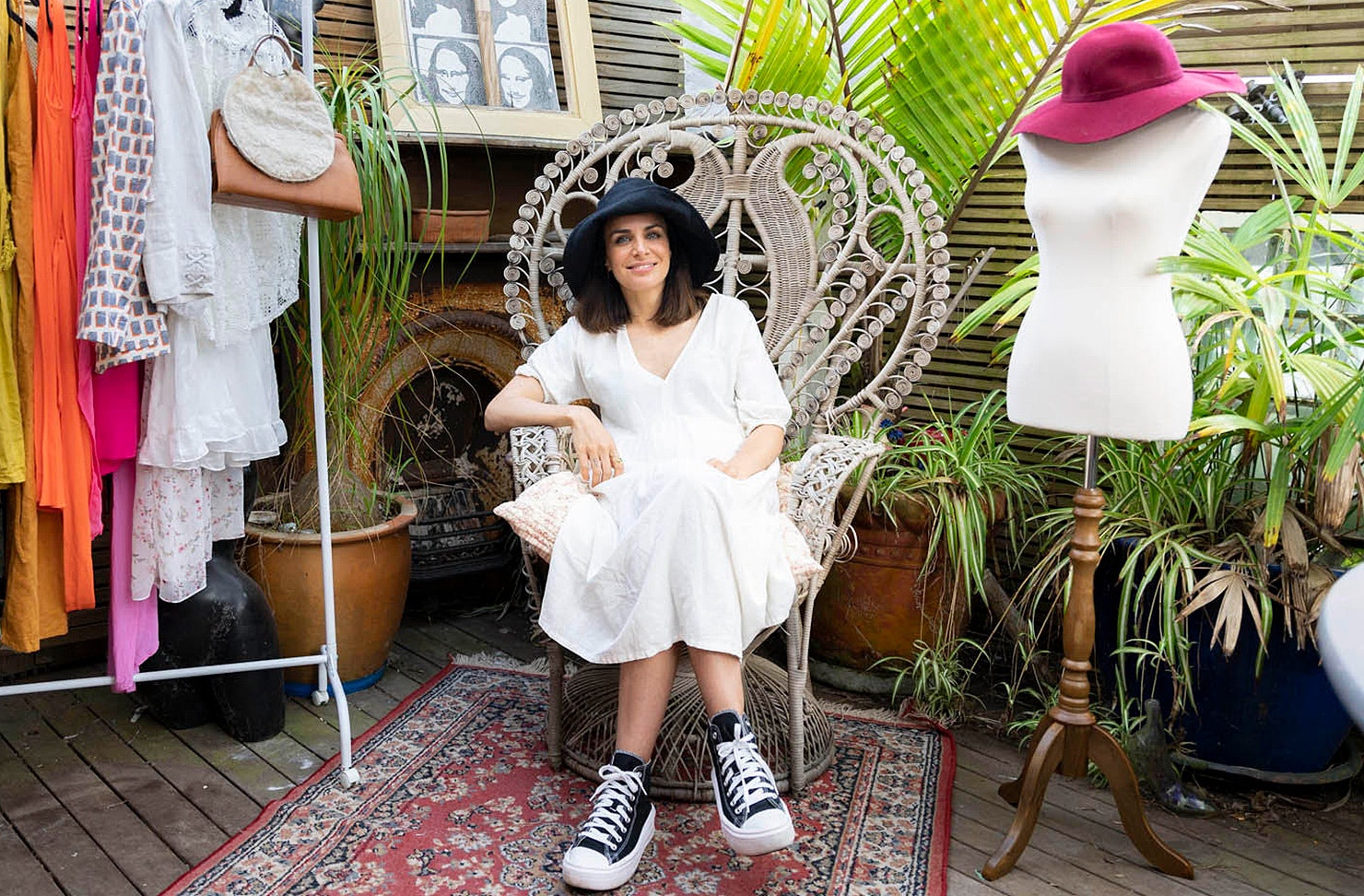 Tabitha Coleman of the Thrift Store sits on a chair surrounded by pre-loved goods.