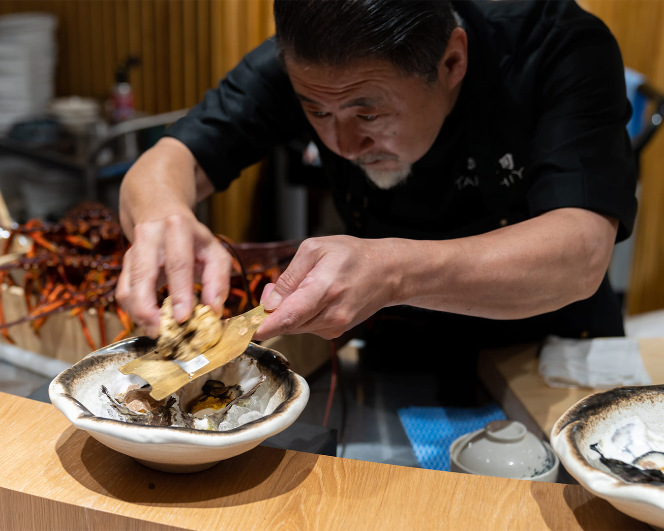 chef takashi plating up sashimi at brisbane restaurant takashiya