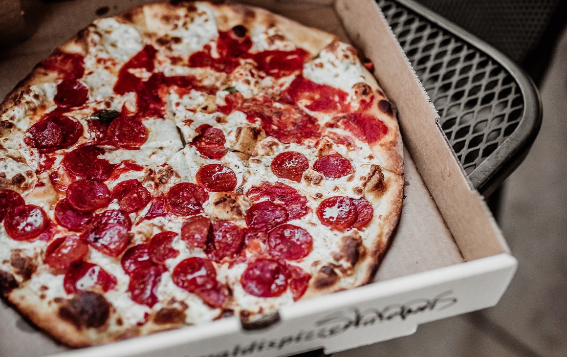 a pizza in a takeaway box