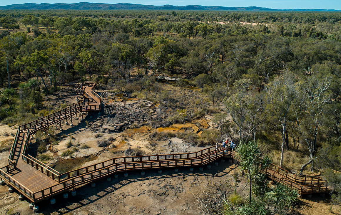 a wooden boardwalk crossing hot springs in the outback